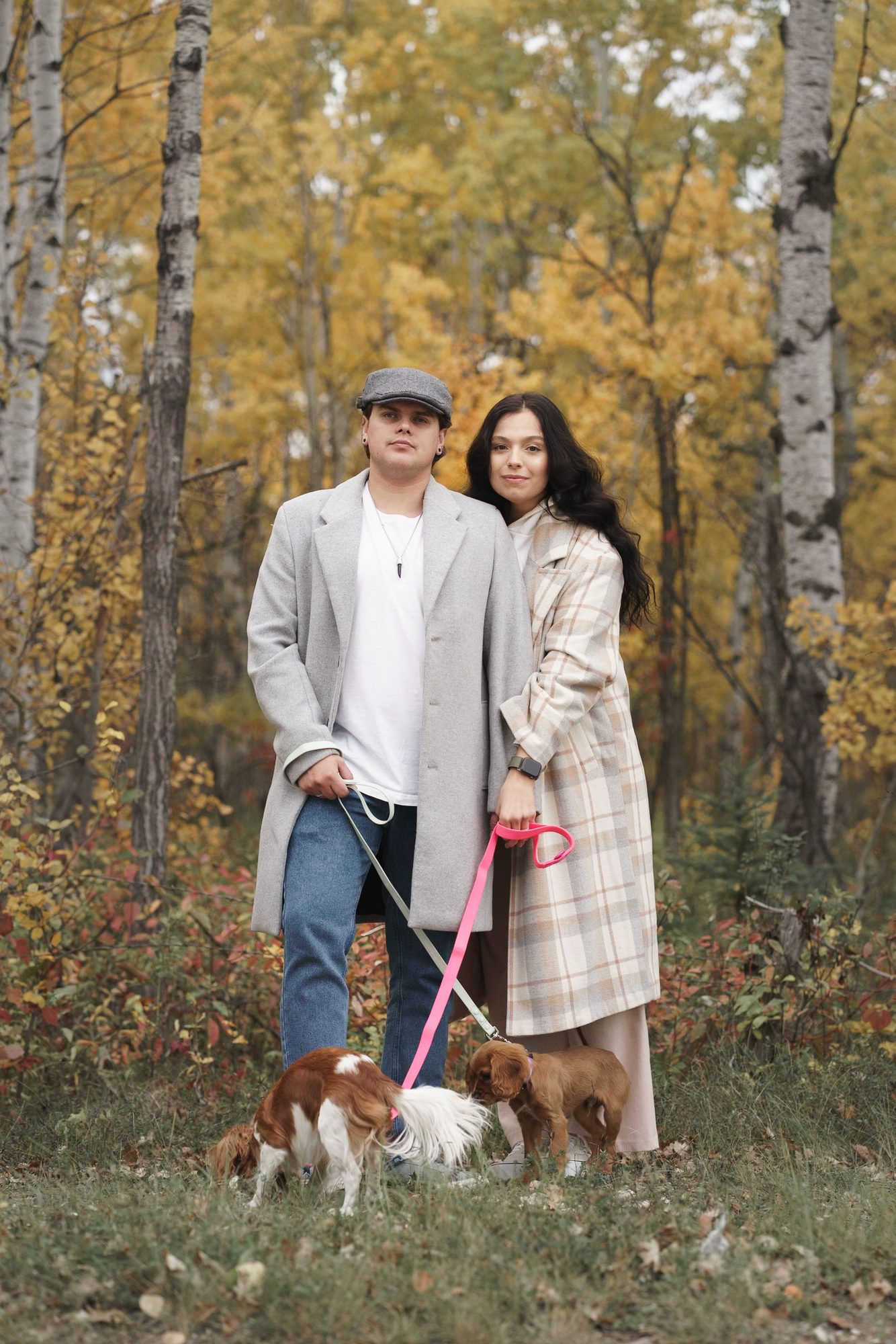 Couple standing together in front of golden birch trees during a fall mini session in Winnipeg