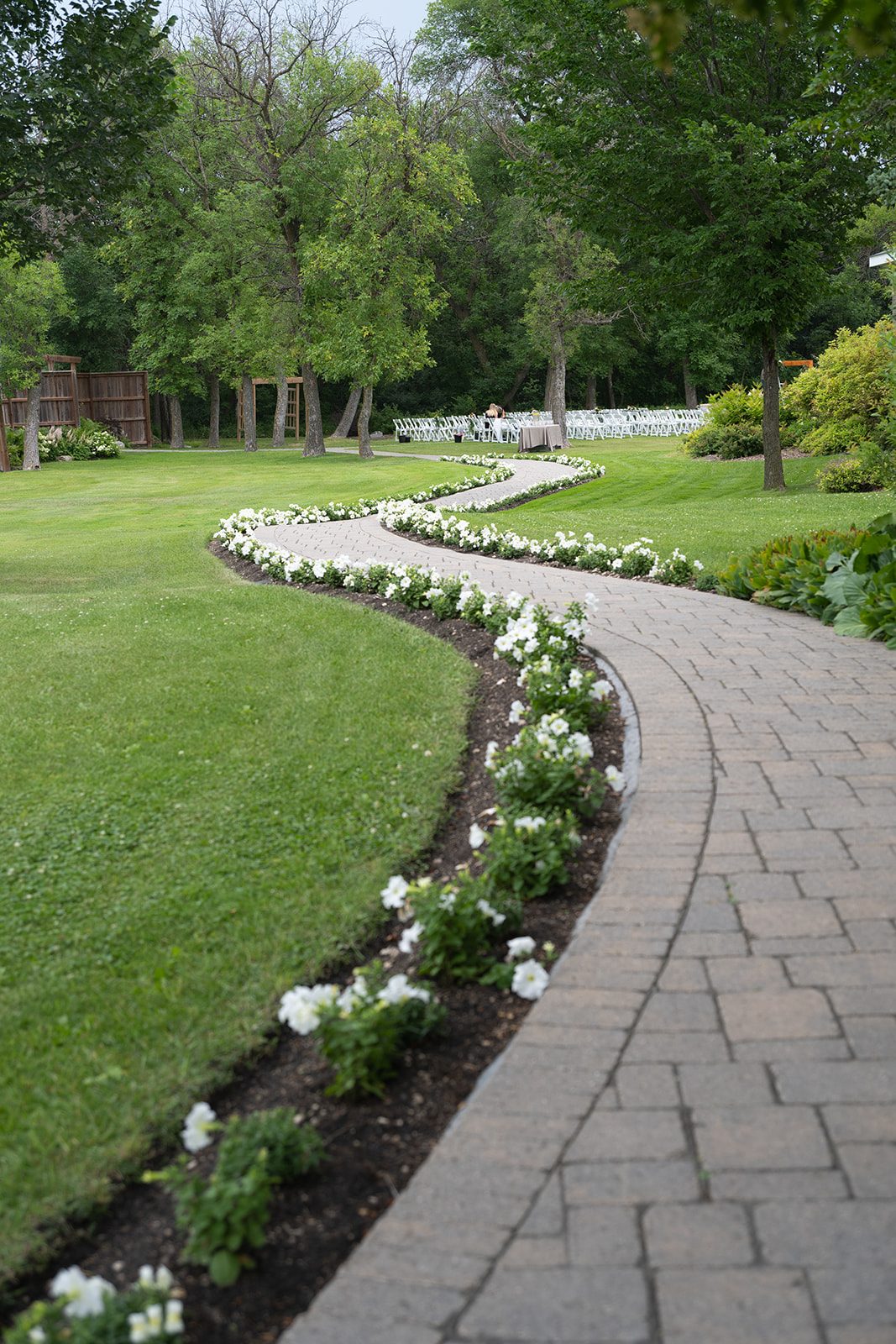 Curving garden path bordered with white flowers on the Breezy Bend Country Club grounds
