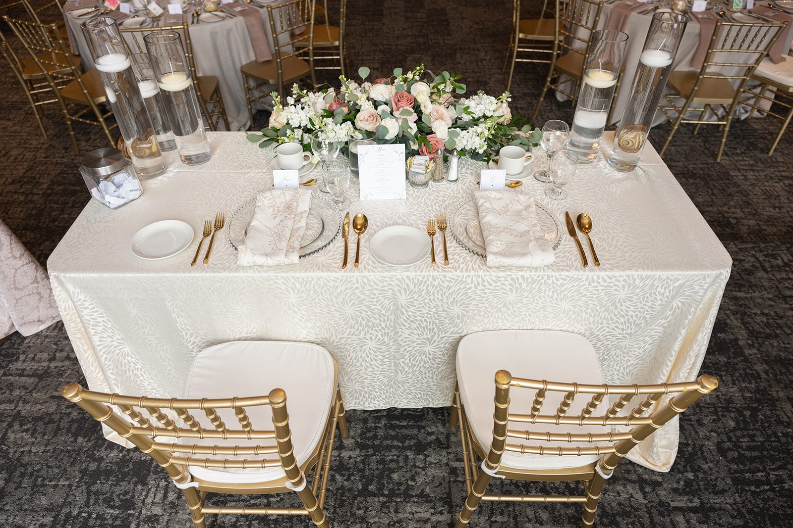 Head table set with gold chairs and low florals at a Breezy Bend Country Club wedding reception